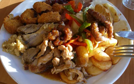 A plate of fried squid, chicken and potatoes
